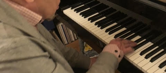 Pierre Kieffer jouant au piano, dans son atelier.
