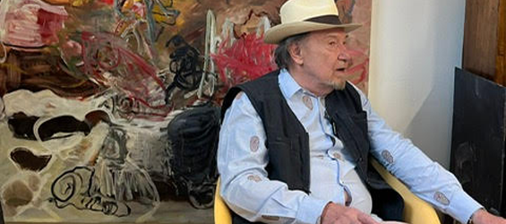 Pierre Kieffer, peintre contemporain, assis dans son atelier devant une grande toile abstraite.